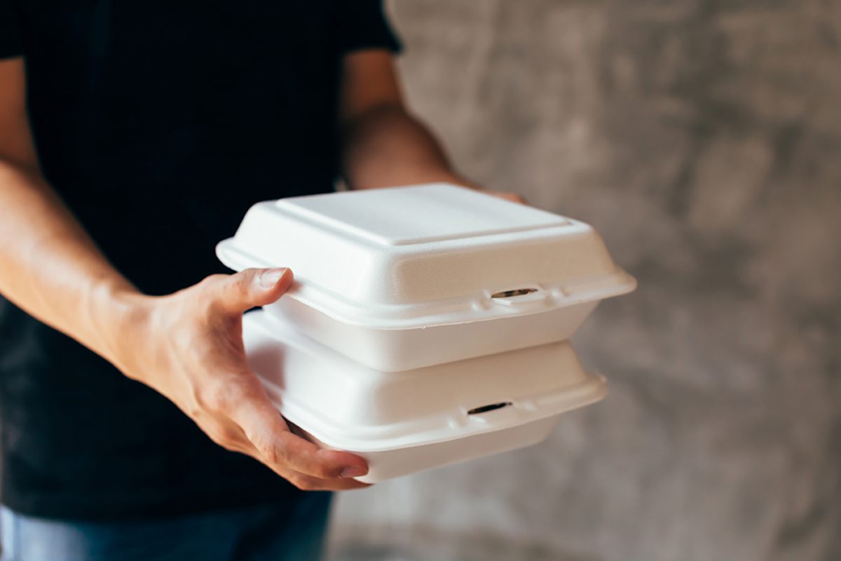 Close Up Of Delivery Man Handing A Slack Of Foam Lunch Box
